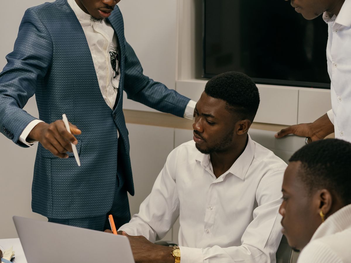 A team working through figures around a laptop
